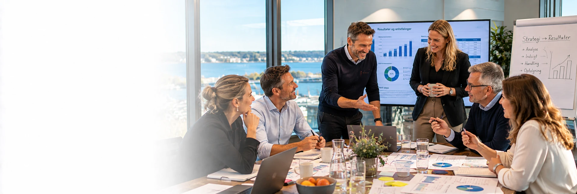 Ledere gennemgår analyseresultater og anbefalinger omkring et mødebord